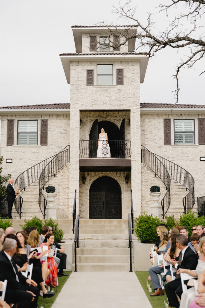 Fort Worth wedding venue bride walking down luxury stairs to outdoor wedding ceremony with glamorous flowers and decor