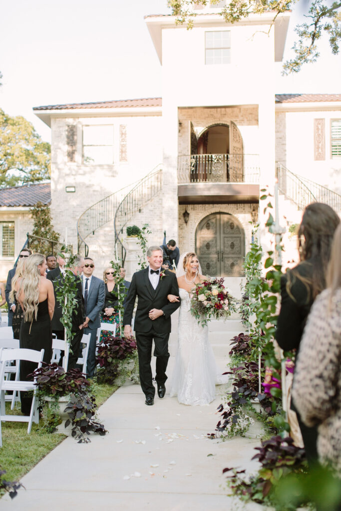 Fort Worth wedding venue outdoor ceremony with luxury bride and groom walking down the aisle greeted by wedding guests. 