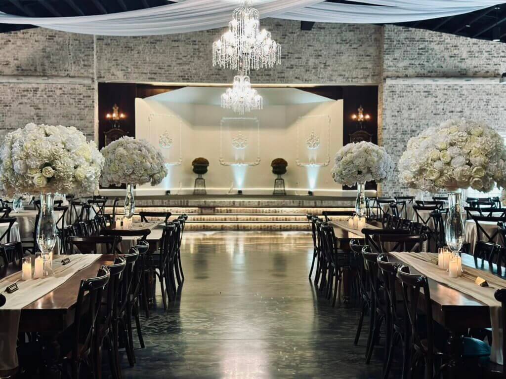 Elegant wedding venue near Fort Worth inspired by a European village, featuring a secret garden, 6400 sq ft ballroom, dressing suites, flowing fountain & modern amenities.
